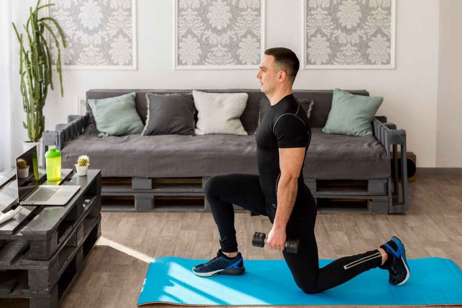 “Man exercising at home using bodyweight movements like squats and lunges”