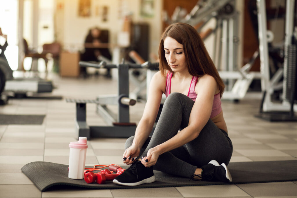 overcoming-fitness-barriers-woman-tying-shoes.