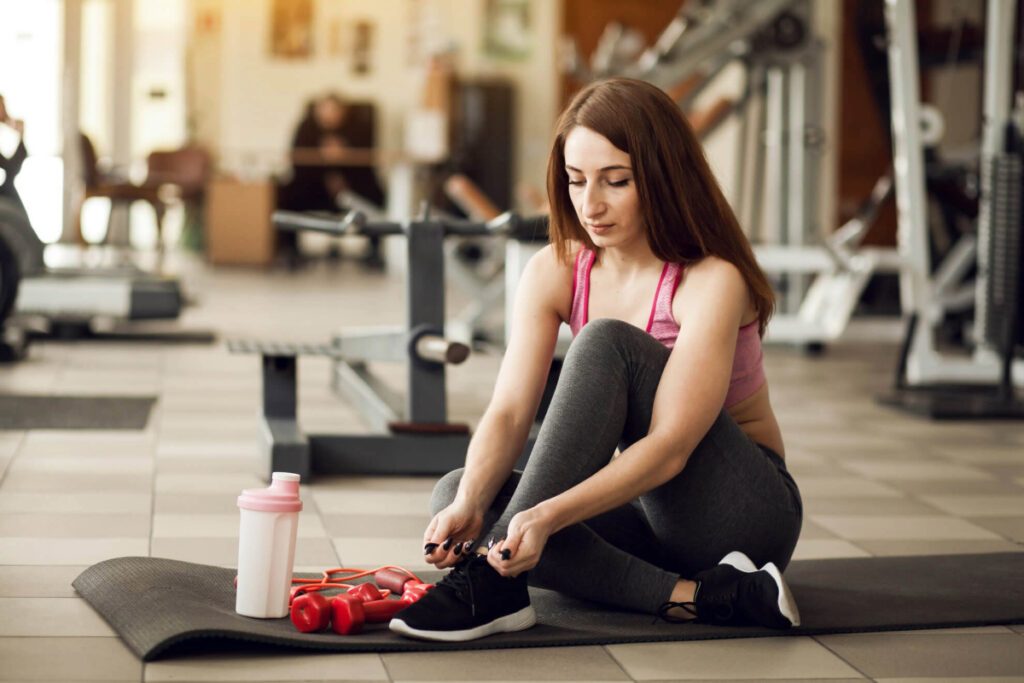 overcoming-fitness-barriers-woman-tying-shoes.